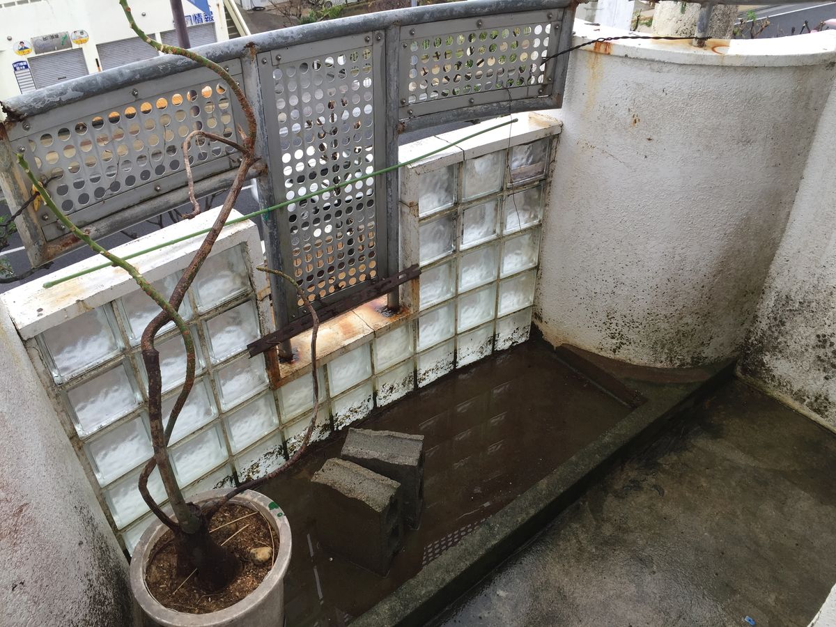 階段横踊場 施工前。カビ汚れと水たまり、サビの見える状態